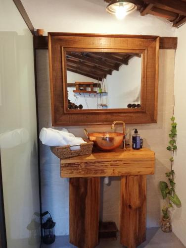 a bathroom with a wooden sink and a mirror at Chalé Rústico Rota Bar 448 in Correia de Almeida