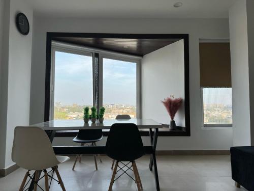 a dining room with a table and chairs and a window at Penta Square Signature Apartments DHA Phase 5 Lahore in Lahore