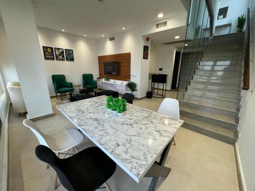a dining room with a table and chairs and stairs at Penta Square Signature Apartments DHA Phase 5 Lahore in Lahore