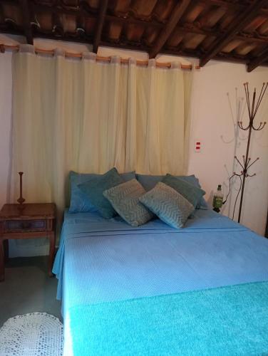 a bed with blue sheets and pillows in a room at Chalé Rústico Rota Bar 448 in Correia de Almeida