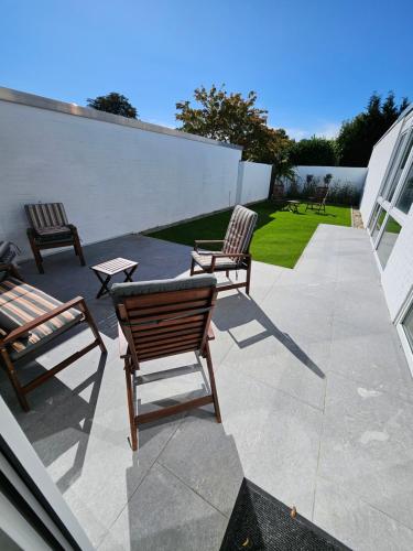 three chairs and a table on a patio at UZ Villa 11 - Modern Living Laatzen in Hannover
