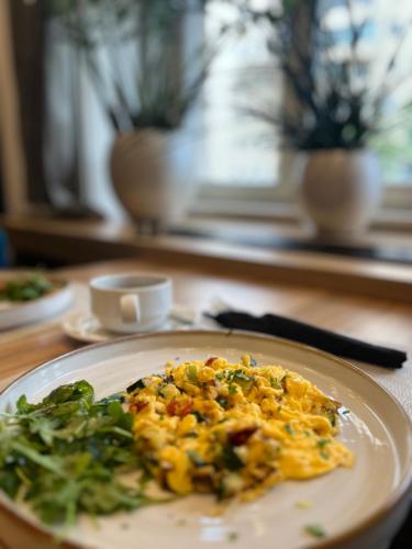 a plate of food with greens on a table at Urban Boutique Hotel Center in Ljubljana