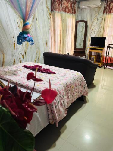 a bedroom with a bed with a pink flowered blanket at Grand adamspeak hotel & restaurant in Adams Peak