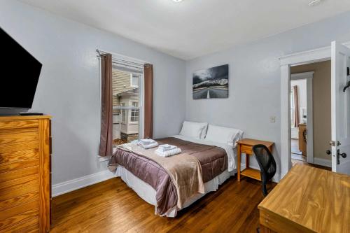 a bedroom with a bed and a desk and a television at 2nd Base Apt 1 All Star Baseball Rentals in Oneonta