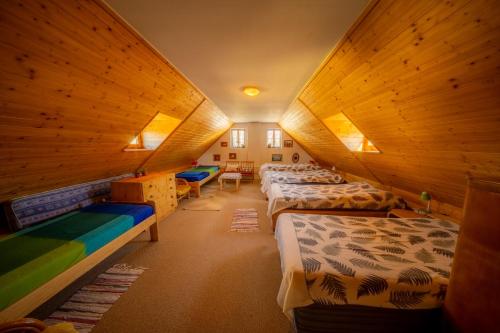 a room with three beds in a room with wooden walls at Ubytování Hrusice in Hrusice