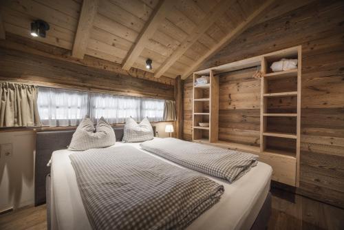 a bedroom with a bed in a wooden room at IM WEIDACH Superior Chalets in Leutasch