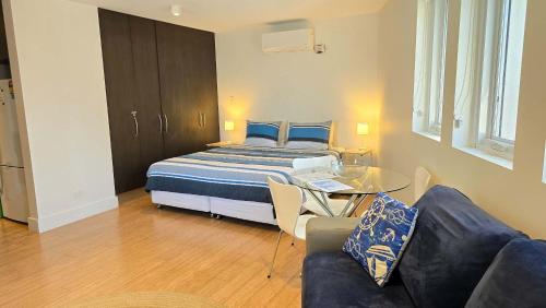 a bedroom with a bed and a glass table at Spacious Studio Surrounded By Great Views in Sydney