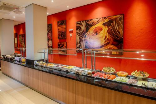 a buffet line with a bunch of pastries at Hotel Centro Europeu in Curitiba