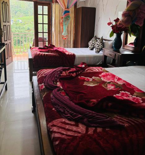a room with two beds with red blankets on them at Grand adamspeak hotel & restaurant in Adams Peak