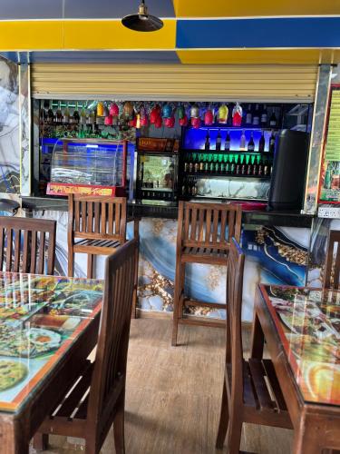 a restaurant with two tables and chairs and a bar at Grand adamspeak hotel & restaurant in Adams Peak