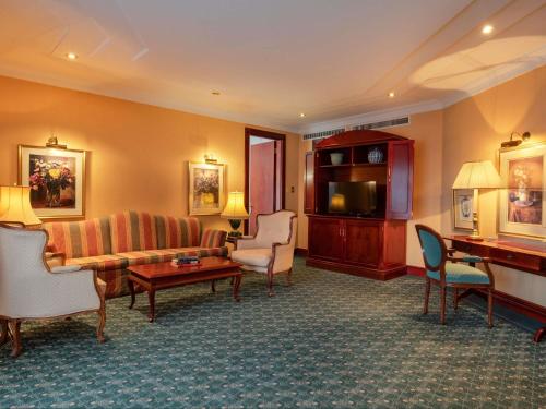 a living room with a couch and a table at Mövenpick Hotel Windhoek in Windhoek