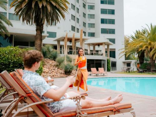 a man and a woman sitting in a chair by a pool at Mövenpick Hotel Windhoek in Windhoek