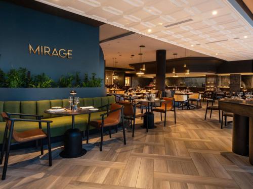 a dining room with tables and chairs in a restaurant at Mövenpick Hotel Windhoek in Windhoek