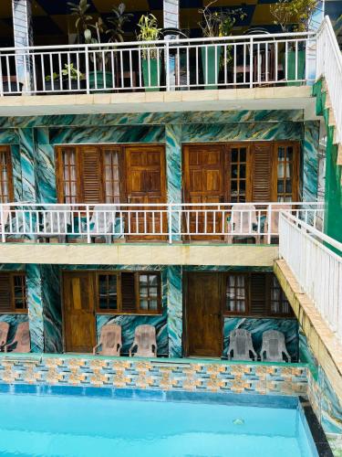 a building with a pool in front of it at Grand adamspeak hotel & restaurant in Adams Peak
