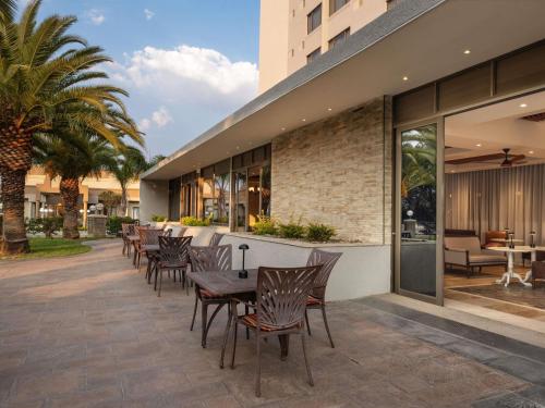 a patio with chairs and a table in front of a building at Mövenpick Hotel Windhoek in Windhoek