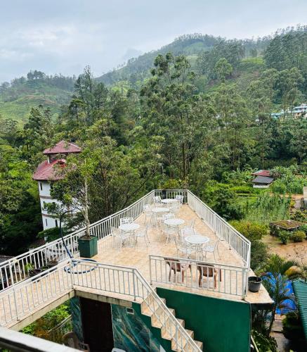 a balcony of a house with tables and chairs at Grand adamspeak hotel & restaurant in Adams Peak
