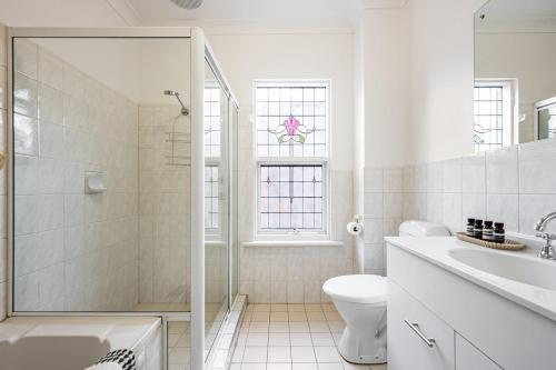 a white bathroom with a toilet and a sink at North Adelaide Townhouse in North Adelaide
