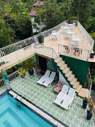 an overhead view of a swimming pool with a deck and chairs at Grand adamspeak hotel & restaurant in Adams Peak
