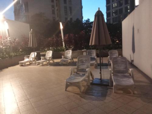 un gruppo di sedie a sdraio e un ombrellone di Rizstar suite at swiss garden Residence bukit Bintang a Kuala Lumpur