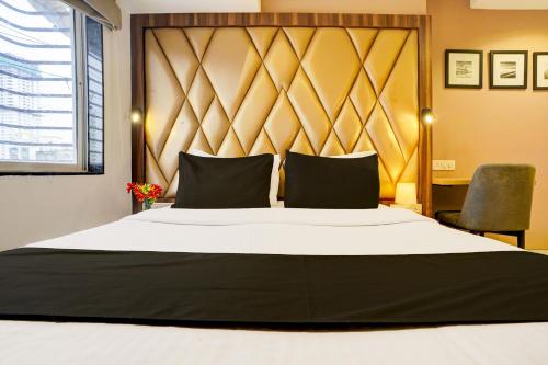 a bedroom with a large bed with a large headboard at Collection O Mumbai Central in Mumbai