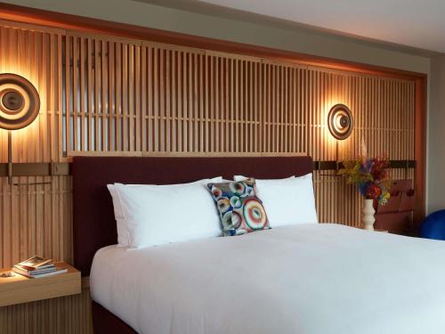 a bedroom with a large white bed and two lamps at SO/ Paris Hotel in Paris