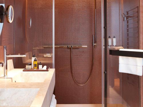 a bathroom with a shower with a glass door at SO/ Paris Hotel in Paris
