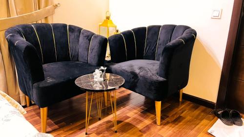 a living room with a blue chair and a glass table at Penta Square Signature Apartments DHA Phase 5 Lahore in Lahore