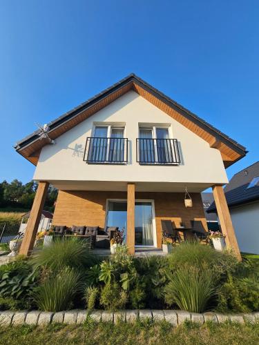a house with a wrap around porch at Dom z Widokiem na Góry i Jacuzzi - "Domki na Słonecznym Wzgórzu" in Lądek-Zdrój