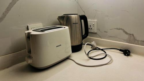 a toaster sitting on a counter next to a coffee maker at Penta Square Signature Apartments DHA Phase 5 Lahore in Lahore