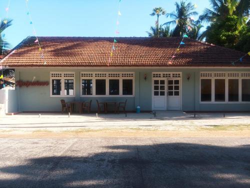 a house with a table and chairs in front of it at Delft Samudra Hotel in Jaffna