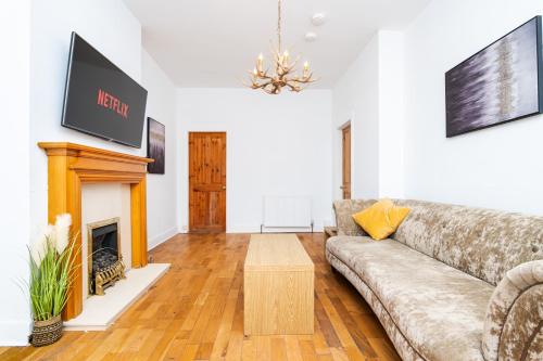 a living room with a couch and a fireplace at 2 Bedroom House - Free Parking in Annan