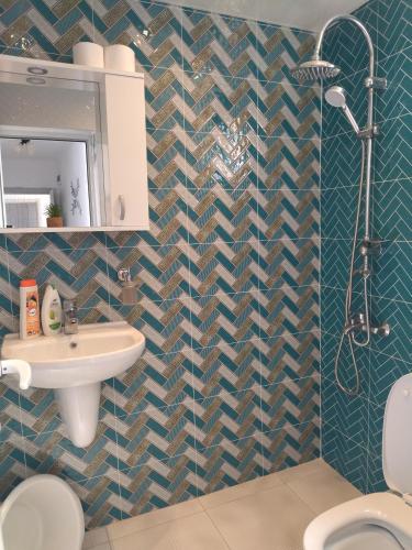 a bathroom with a sink and a toilet at Къща за гости ИЛТА in Novo Delchevo