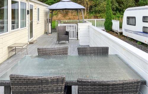 a patio with a table and chairs and an umbrella at 2 Bedroom Cozy Home In Lindesnes in Spangereid