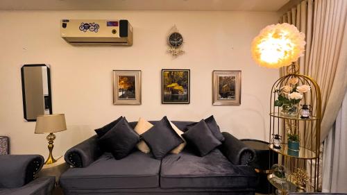 a living room with a couch and pictures on the wall at Penta Square Signature Apartments DHA Phase 5 Lahore in Lahore