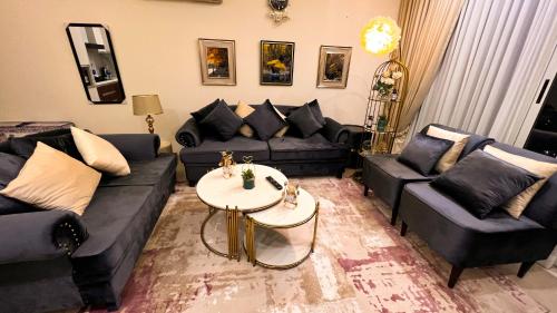 a living room with couches and a table at Penta Square Signature Apartments DHA Phase 5 Lahore in Lahore