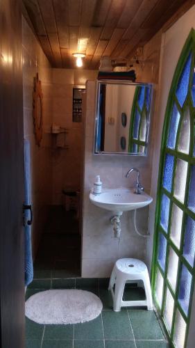 a bathroom with a sink and a mirror at Quarto Duplo, Casa da Jô in Angra dos Reis