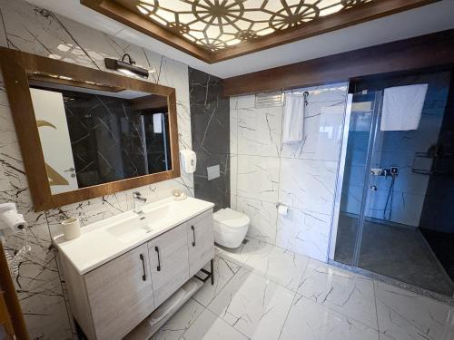 un bagno con lavandino, doccia e specchio di Mira Hotel Küçükyalı a Smirne