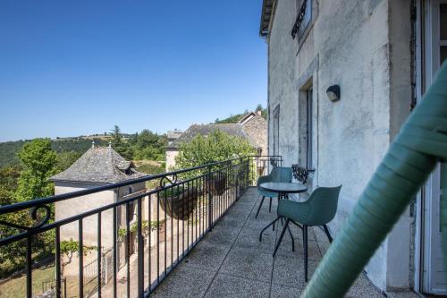 a balcony with a table and chairs on it at L'Oustal Del Barry in Najac