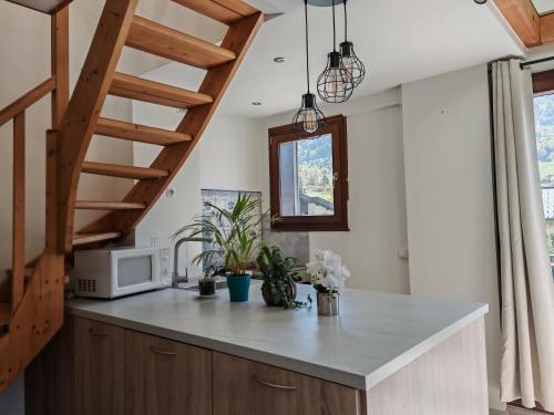eine Küche mit einer Theke mit einer Mikrowelle und einer Treppe in der Unterkunft Beau duplex lumineux à la montagne Nice flat just underneath MtBlanc in Les Houches