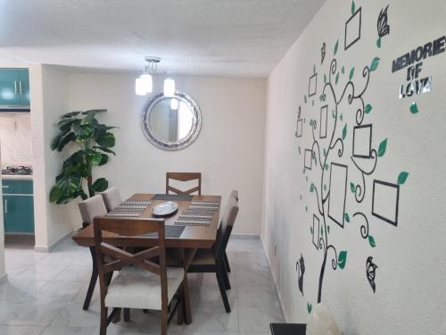 Un comedor con mesa y sillas en El depa de Natalia a min de aeropuerto y estadio GNP, en Ciudad de México