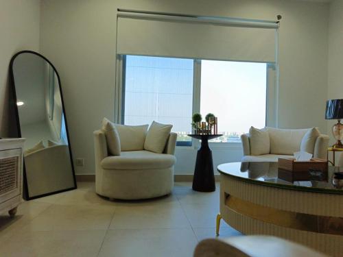 a living room with a chair and a window at Penta Square Signature Apartments DHA Phase 5 Lahore in Lahore