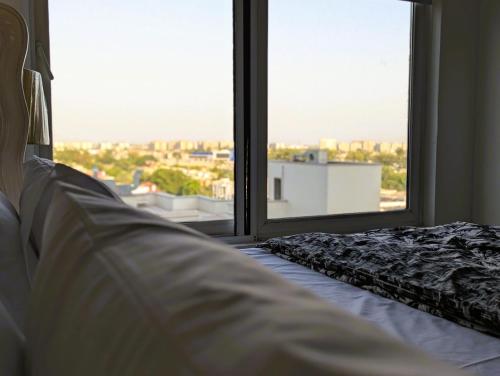 a bedroom with a bed and a large window at Penta Square Signature Apartments DHA Phase 5 Lahore in Lahore