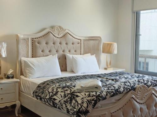 a bedroom with a large bed with white pillows at Penta Square Signature Apartments DHA Phase 5 Lahore in Lahore