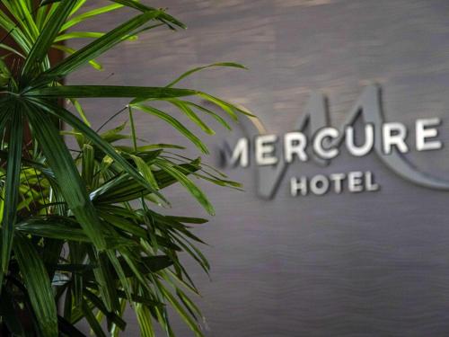 a green plant in front of a hotel sign at Mercure Rosario in Rosario