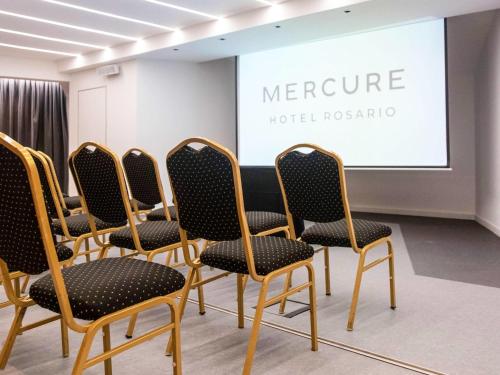 a row of chairs in front of a screen at Mercure Rosario in Rosario