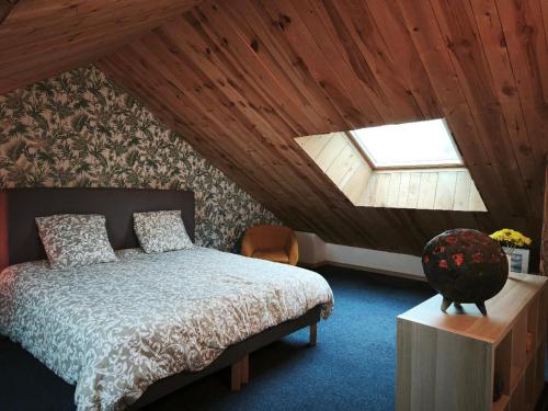 une chambre avec un lit et une lucarne dans l'établissement Gîte du Feuil, à Blassac