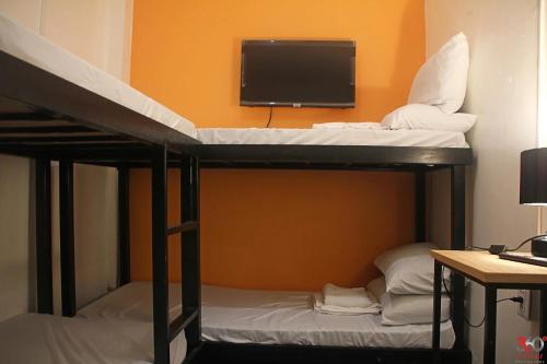 a room with two bunk beds with a flat screen tv at Adventourist Inn Coron in Coron