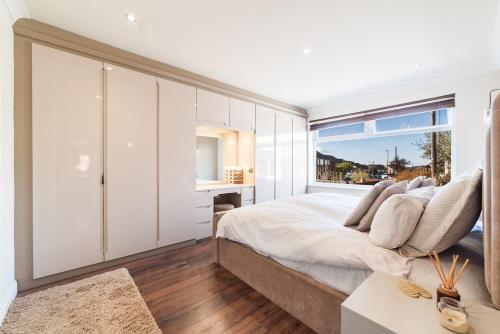 ダーウェンにある2 Bed Modern Bungalow in Darwen, Garden & Parkingの大きなベッドと窓のある寝室