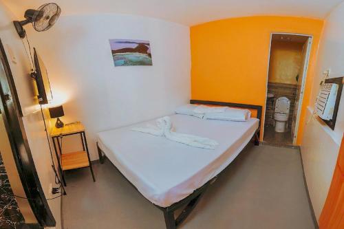 a bedroom with a bed in a room with a toilet at Adventourist Inn Coron in Coron