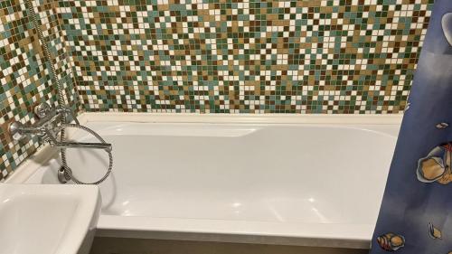 een badkamer met een wit bad en een douchegordijn bij Imantas in Daugavpils